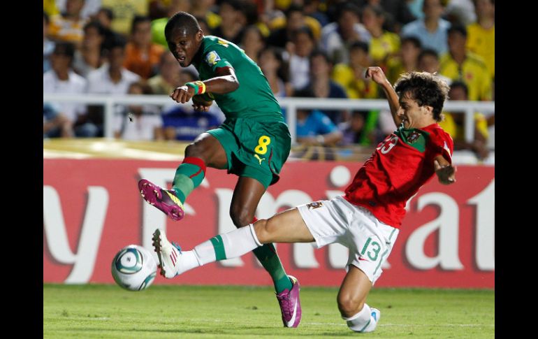 Emmanuel Mbongo, de Camerún, intenta un tiro mientras Luis Martins, de Portugal, busca bloquearlo. AP  /