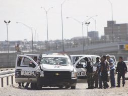 Policías y peritos revisan la patrulla baleada. El ataque fue perpetrado debajo del puente internacional Córdova Américas. EFE  /