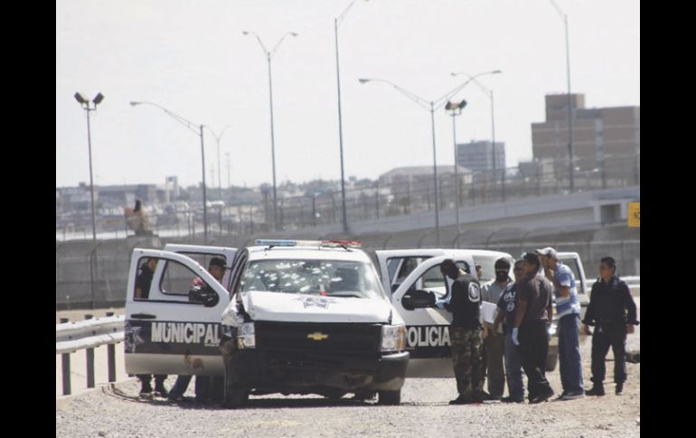 Policías y peritos revisan la patrulla baleada. El ataque fue perpetrado debajo del puente internacional Córdova Américas. EFE  /