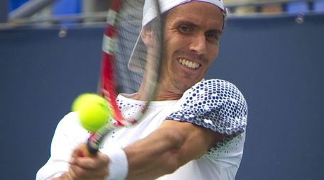 El tenista argentino Juan Ignacio Chela devuelve una bola ante el canadiense Vasek Pospisil. EFE  /