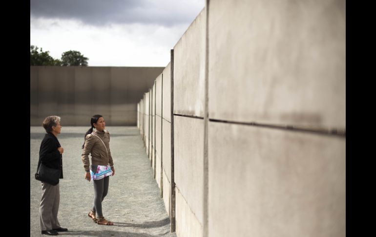 Turistas visitan parte reconstruida del muro de Berlín en el Monumento a la pared en la Bernauer Strasse en Berlín. AP  /