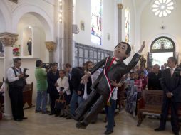 Un hombre sostiene una figura de ''Cantinflas'' durante la misa a la que asistieron familiares y seguidores. AFP  /