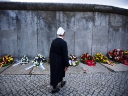 Una enferemera acude al sitio donde se ofrecen ramos de flores en memoria de las víctimas. AP  /