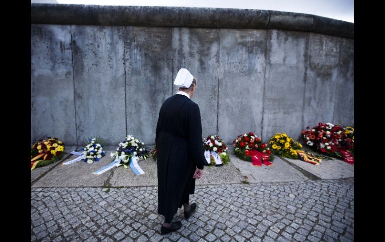 Una enferemera acude al sitio donde se ofrecen ramos de flores en memoria de las víctimas. AP  /