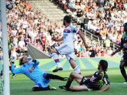 Lisandro Lopez, del Lyon (C) envia un gol para Guillermo Ochoa (I) en el marco del empate del torneo francés.AFP  /