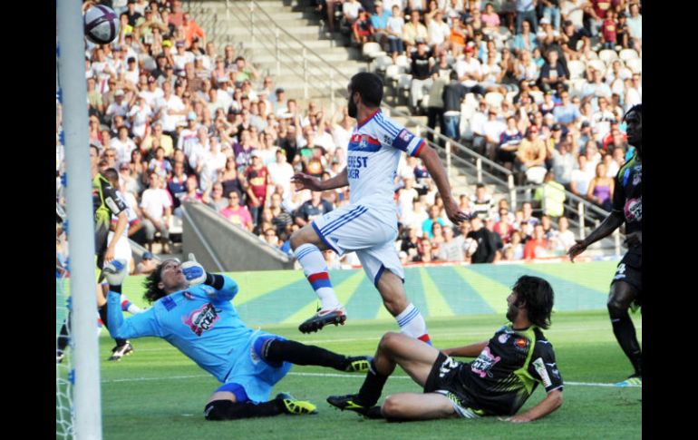 Lisandro Lopez, del Lyon (C) envia un gol para Guillermo Ochoa (I) en el marco del empate del torneo francés.AFP  /