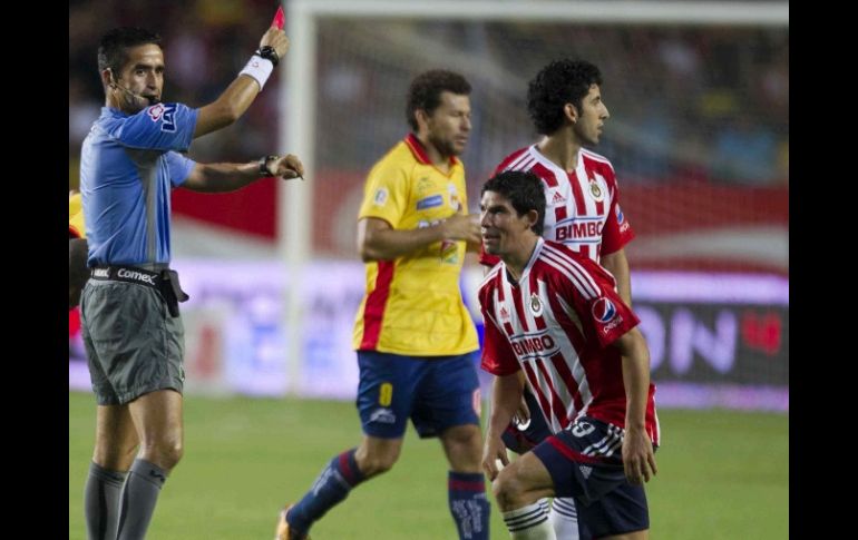 El árbitro, Juan Medrano, expulsa al jugador de las Chivas, Jonny Magallón, en encuentro ante el Morelia. MEXSPORT  /