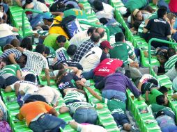 Espectadores ingresaron al terreno de juego en busca de una salida, otros se tiraron al piso. AFP  /