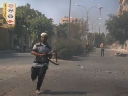 Un rebelde va a cubrir en una calle de Zawiya, Libia. AP  /