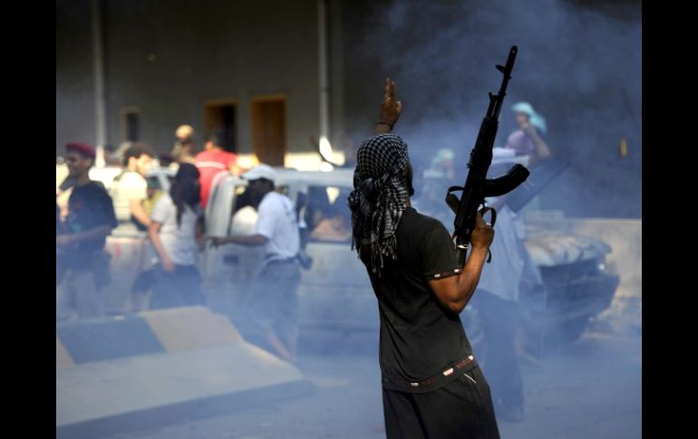 Un rebelde libio celebra hoy dentro de la base militar capturada a 16 kilómetros de Trípoli. AFP  /