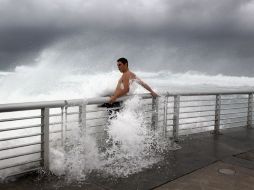 Cory Ritz se aferra a la protección del muelle en la Playa de Boynton, en Florida. AFP  /