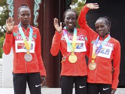 Edna Kiplagat (ctr), Priscah Jeptoo (izq) y Sharon Cheropposan (der) con sus respectivas medallas. EFE  /