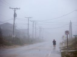 Una mujer se ejercita hoy bajo la lluvia del huracán 'Irene', que ya cobró su primera víctima. EFE  /