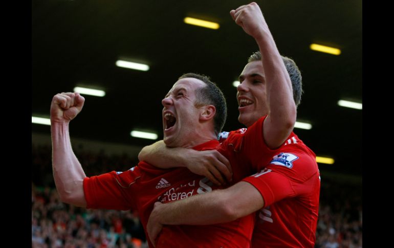 El jugador de Liverpool, Charlie Adam (I)felicita a Jordan Henderson después de anotar gol ante Bolton. AP  /