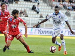 El mediocampista Burkinabe del Auxerre disputa el balón con Alain Traoré (D) y contra el defensa del Ajaccio Anthony Lippini.AFP  /