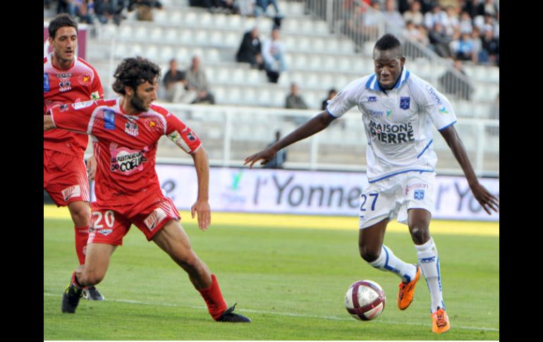 El mediocampista Burkinabe del Auxerre disputa el balón con Alain Traoré (D) y contra el defensa del Ajaccio Anthony Lippini.AFP  /