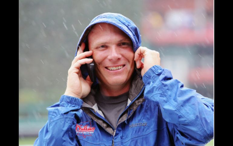 Mike Boekholder de los Filis de Filadelfia avisa en el teléfono que el juego contra los Marlins de Florida se cancela. AFP  /