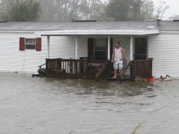 En la imagen, Jarod Wilton mira cómo el agua del diluvio rodea su casa. AP  /