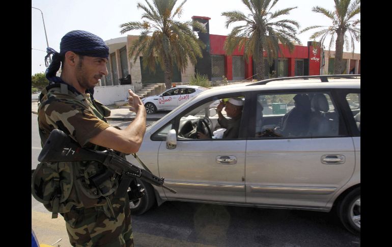 Un rebelde libio organiza el tráfico en un punto de control rebelde en Trípoli. EFE  /