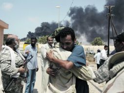 El comandante rebelde Mustafa Rubba abraza a un trabajador petrolero a su regreso a la estación de control de una refinería. REUTERS  /