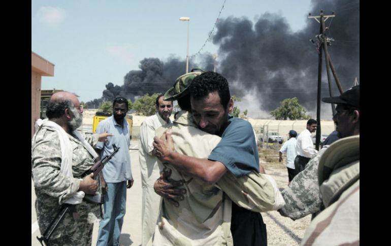 El comandante rebelde Mustafa Rubba abraza a un trabajador petrolero a su regreso a la estación de control de una refinería. REUTERS  /