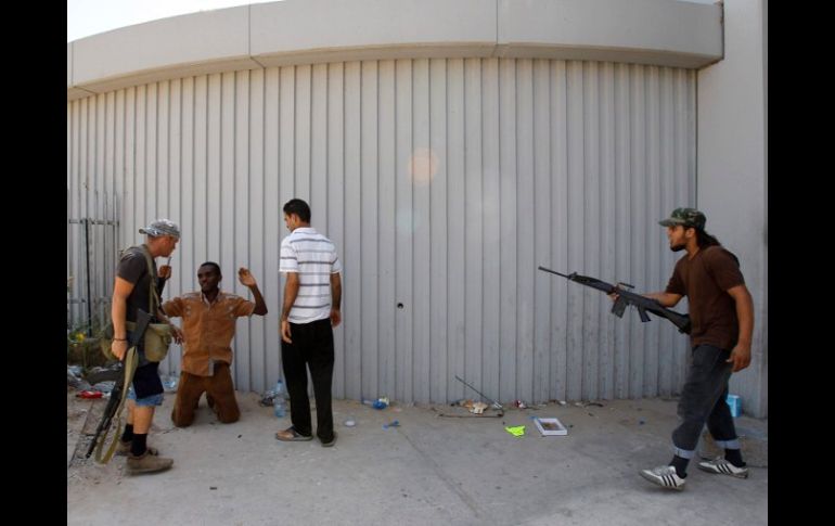 Un hombre acusado de ser mercenario al servicio de Gadhafi se rinde hoy, en las calles de Libia. REUTERS  /