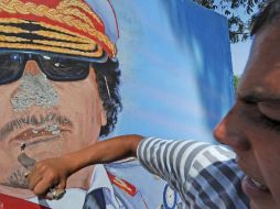 Un hombre destroza un mural en el cuartel del 32 regimiento en la capital libia. EFE  /