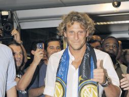 El uruguayo Diego Forlán saluda a los seguidores del Inter que lo esperaban a su llegada al aeropuerto de Milán. AP  /