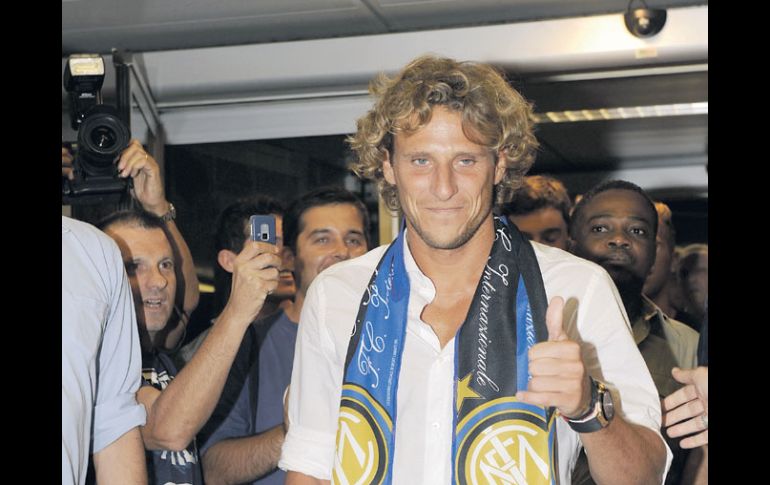 El uruguayo Diego Forlán saluda a los seguidores del Inter que lo esperaban a su llegada al aeropuerto de Milán. AP  /