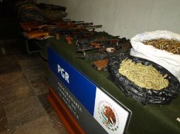 En la foto: narcóticos, arsenal y vestimenta tipo militar confiscados. ESPECIAL  /