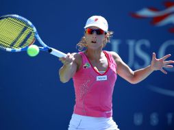 La tenista española, Nuria Llagostera Vives, devuelve la bola a la tenista del equipo de Dinamarca, Caroline Wozniacki. AFP  /