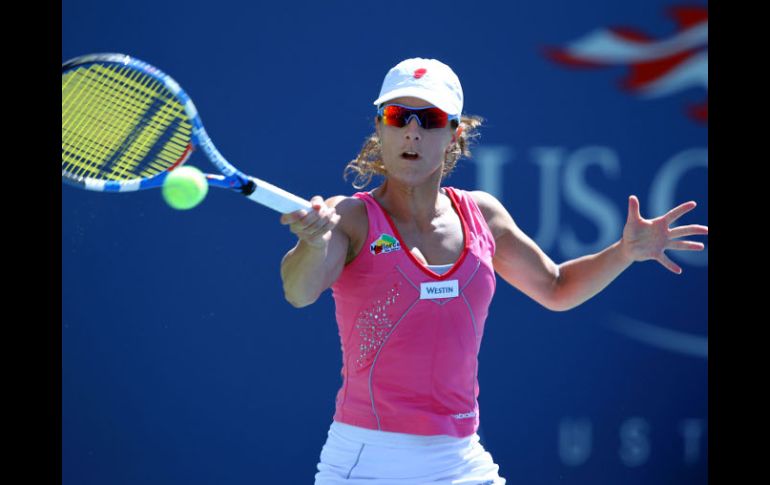 La tenista española, Nuria Llagostera Vives, devuelve la bola a la tenista del equipo de Dinamarca, Caroline Wozniacki. AFP  /