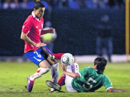 El jugador chileno Paulo Magalhaes disputa el balón con el mexicano Darvin Chávez. EFE  /