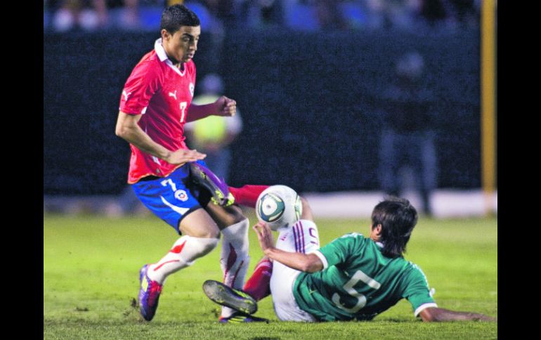 El jugador chileno Paulo Magalhaes disputa el balón con el mexicano Darvin Chávez. EFE  /