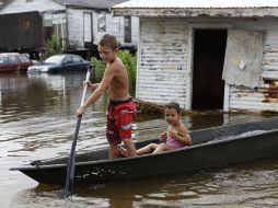 Terren Verdin, ''T-Chico'', de siete años juega en las crecidas aguas traídas por la tormenta “Lee” fuera de su casa. AP  /