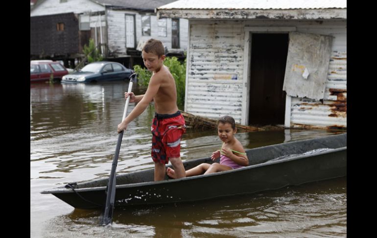 Terren Verdin, ''T-Chico'', de siete años juega en las crecidas aguas traídas por la tormenta “Lee” fuera de su casa. AP  /