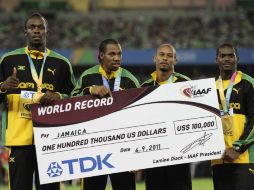 (De izq a der) Usain Bolt, Yohan Blake, Michael Frater, Nesta Carter con su medalla de Oro y el cheque por el nuevo récord mundial. AP  /