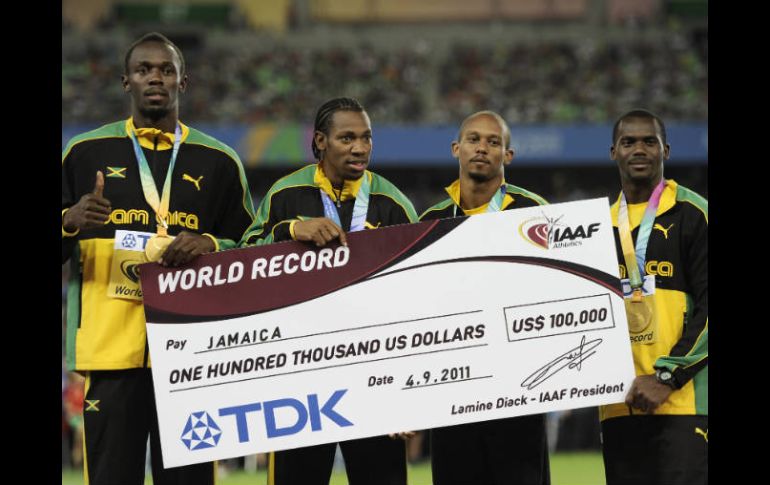 (De izq a der) Usain Bolt, Yohan Blake, Michael Frater, Nesta Carter con su medalla de Oro y el cheque por el nuevo récord mundial. AP  /