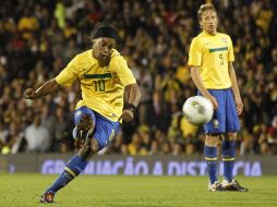 Ronaldinho  (I)  hace un pase libre en el partido contra Ghana, a un lado,  Lucas Leiva observa al brasileño. AP  /