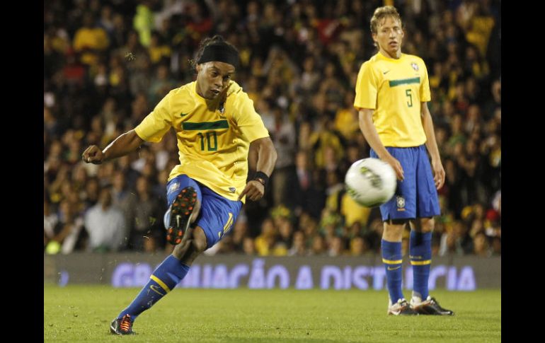 Ronaldinho  (I)  hace un pase libre en el partido contra Ghana, a un lado,  Lucas Leiva observa al brasileño. AP  /