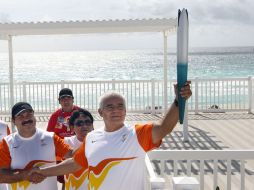 El campeón panamericano de gimnasia (1975), Rogelio Mendoza porta la Antorcha Panamericana en el recorrido por Cancún. EFE  /