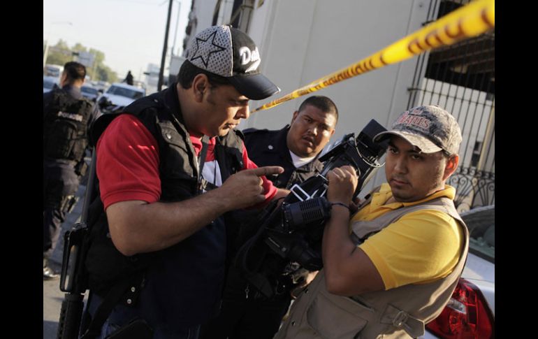 Un elemento de seguridad impide a un camarógrafo grabar el saldo de la balacera entre policías y delincuentes en Monterrey. REUTERS  /