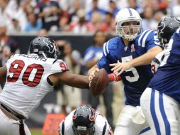 Kerry Collins (5) es presionado por Mario Williams de los Texanos de Houston (90). AP  /