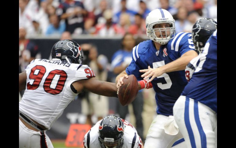 Kerry Collins (5) es presionado por Mario Williams de los Texanos de Houston (90). AP  /