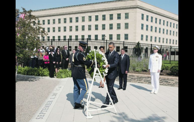 Barack Obama (derecha), coloca un arreglo floral como parte del homenaje por el décimo aniversario del 11 de septiembre de 2001. EFE  /