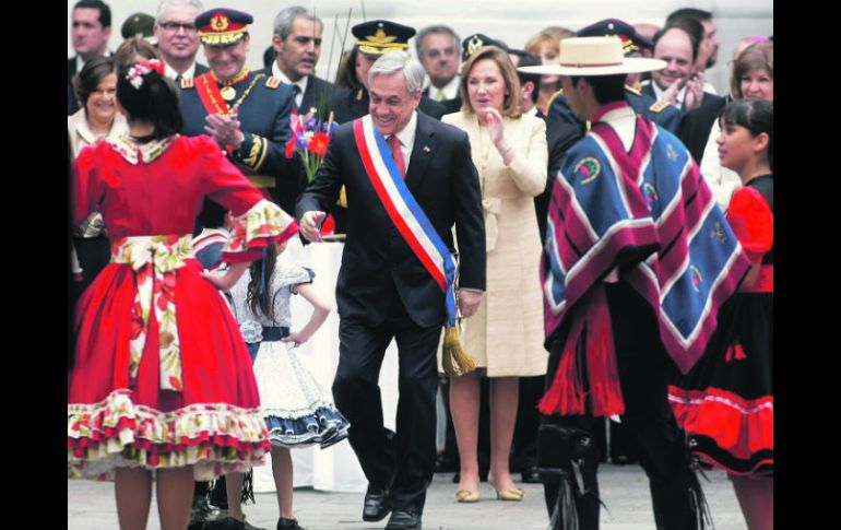 Sebastián Piñera saluda a bailarines de un conjunto tradicional en el Palacio de La Moneda, tras encabezar el tradicional Tedéum. EFE  /