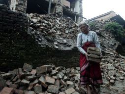 Una anciana recupera sus pertenencias entre los escombros de su vivienda en Bhaktapur, Nepal. EFE  /