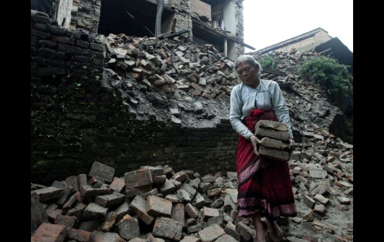 Una anciana recupera sus pertenencias entre los escombros de su vivienda en Bhaktapur, Nepal. EFE  /