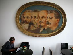 Marx, Engels, Lenin y Stalin desde un óleo ven a un hombre trabajar en su laptop en el nuevo museo de Sofía. REUTERS  /