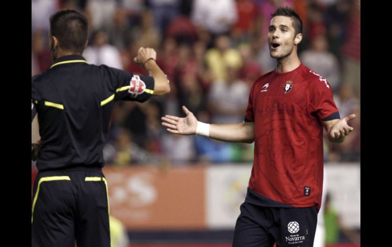 El jugador de Osasuna Kike Solá (d) pide explicaciones al árbitro tras el gol que le anuló ante el Sevilla. EFE  /